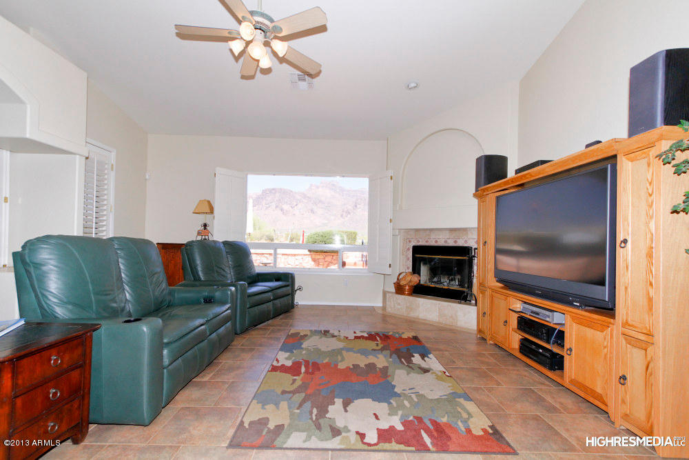 365 North Muleshoe Road Apache Junction, AZ 85119 - Photo 14 of 54 a living room with furniture a flat screen tv and a fireplace
