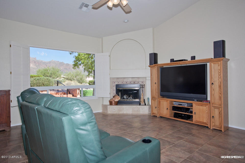 365 North Muleshoe Road Apache Junction, AZ 85119 - Photo 19 of 54 a living room with furniture a flat screen tv and a fireplace