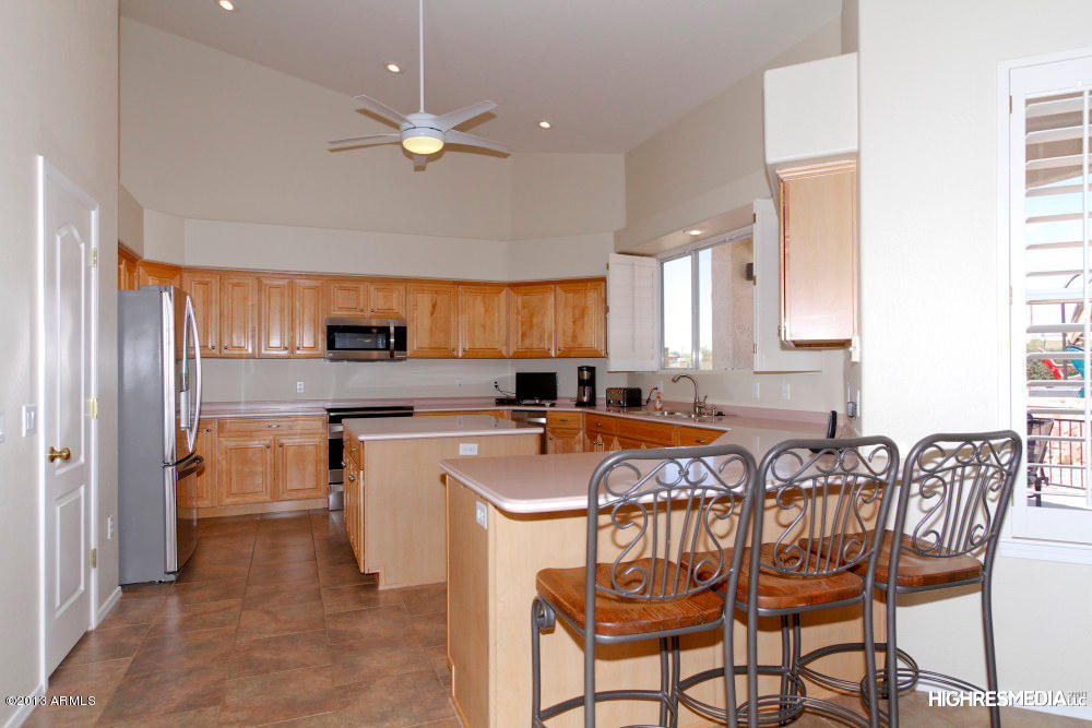 365 North Muleshoe Road Apache Junction, AZ 85119 - Photo 23 of 54 a kitchen with stainless steel appliances a table chairs refrigerator and sink