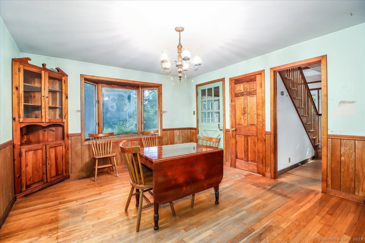 16 Farrell Road Newtown, CT 06470 - Photo 29 of 38 a dining room with wooden floor furniture and a chandelier