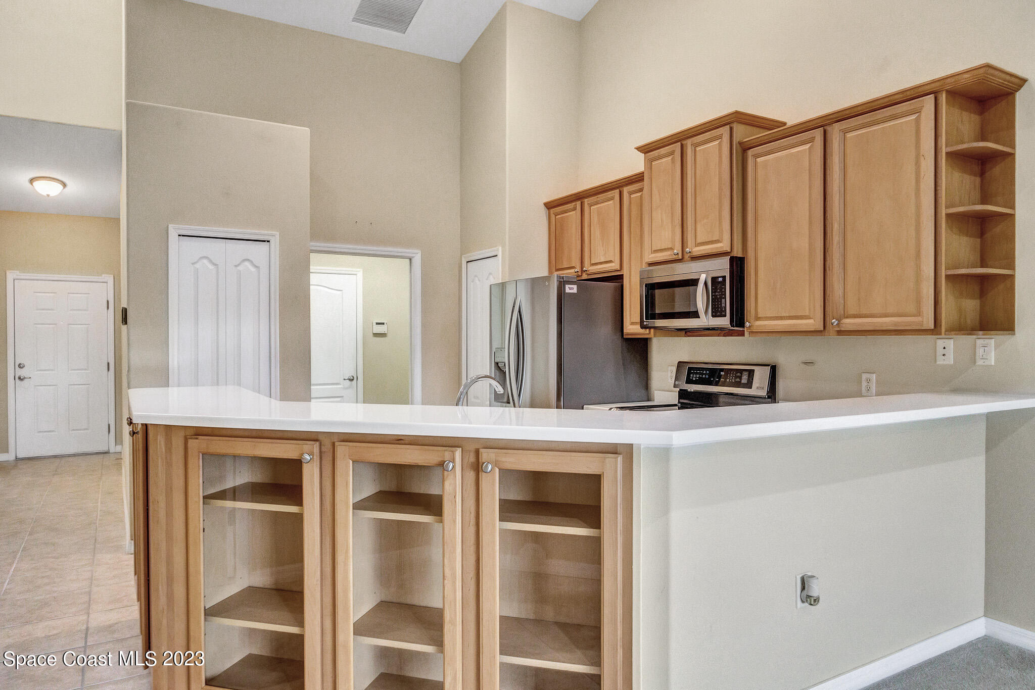 3071 Le Conte Street Melbourne, FL 32940 - Photo 8 of 41 a kitchen with stainless steel appliances granite countertop a refrigerator a stove top oven and white cabinets
