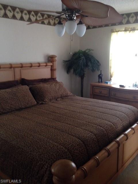 4338 27th Court Southwest, Unit 8201 Naples, FL 34116 - Photo 14 of 19 a bedroom with a bed and a potted plant