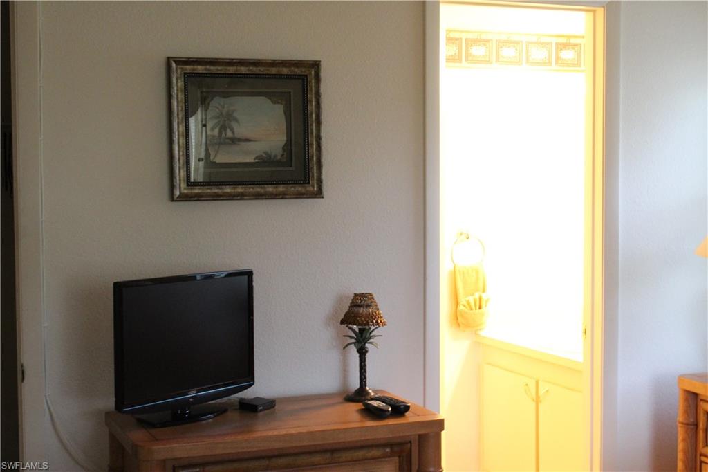 4338 27th Court Southwest, Unit 8201 Naples, FL 34116 - Photo 15 of 19 a living room with a flat screen tv and a window