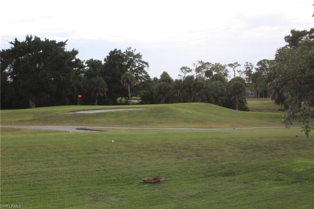 4338 27th Court Southwest, Unit 8201 Naples, FL 34116 - Photo 19 of 19 a view of a field with trees in the background