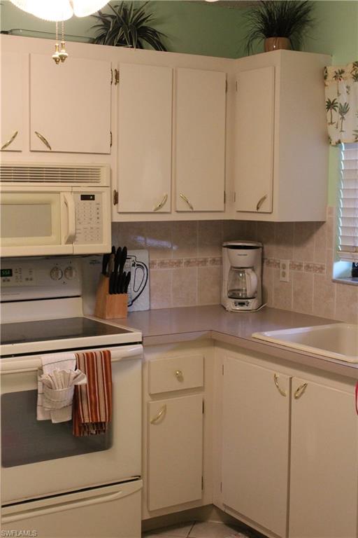 4338 27th Court Southwest, Unit 8201 Naples, FL 34116 - Photo 2 of 19 a kitchen with a sink and cabinets