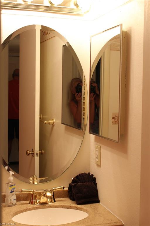 4338 27th Court Southwest, Unit 8201 Naples, FL 34116 - Photo 5 of 19 a bathroom with a sink and a mirror