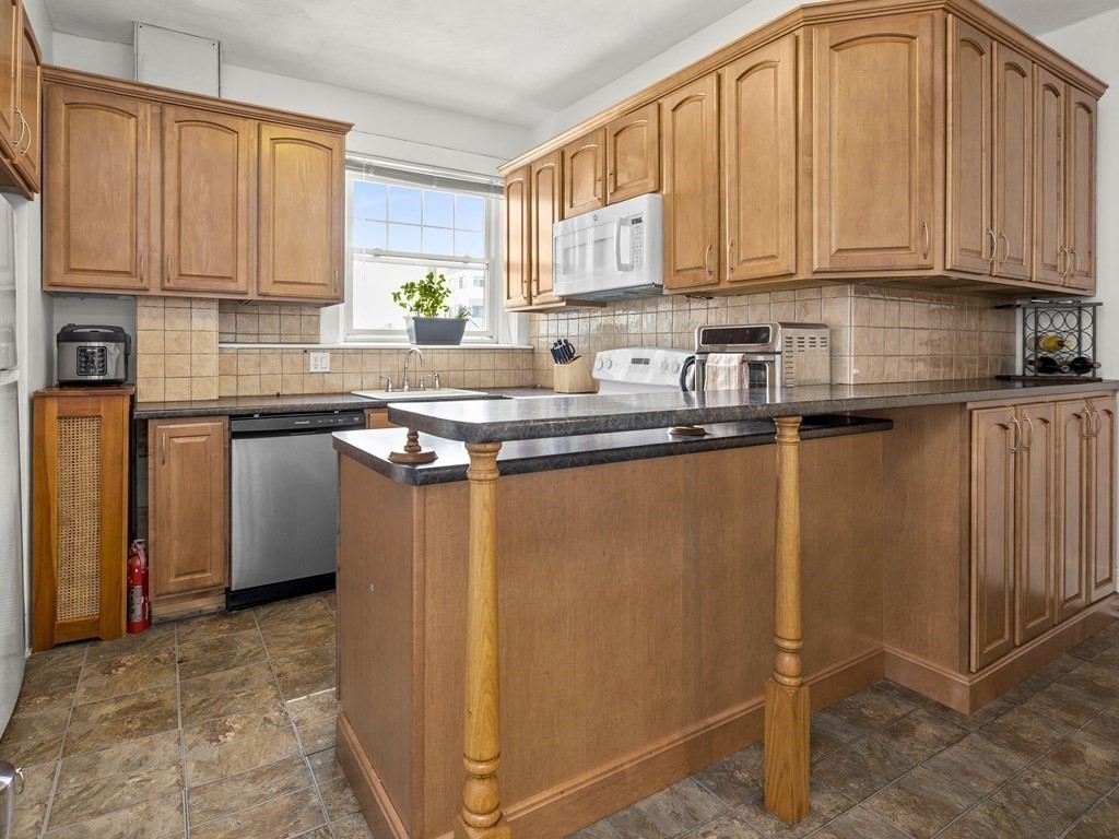 5 Spofford Road, Unit 8 Boston, MA 02134 - Photo 4 of 20 a kitchen with stainless steel appliances granite countertop a stove a sink a refrigerator and white cabinets