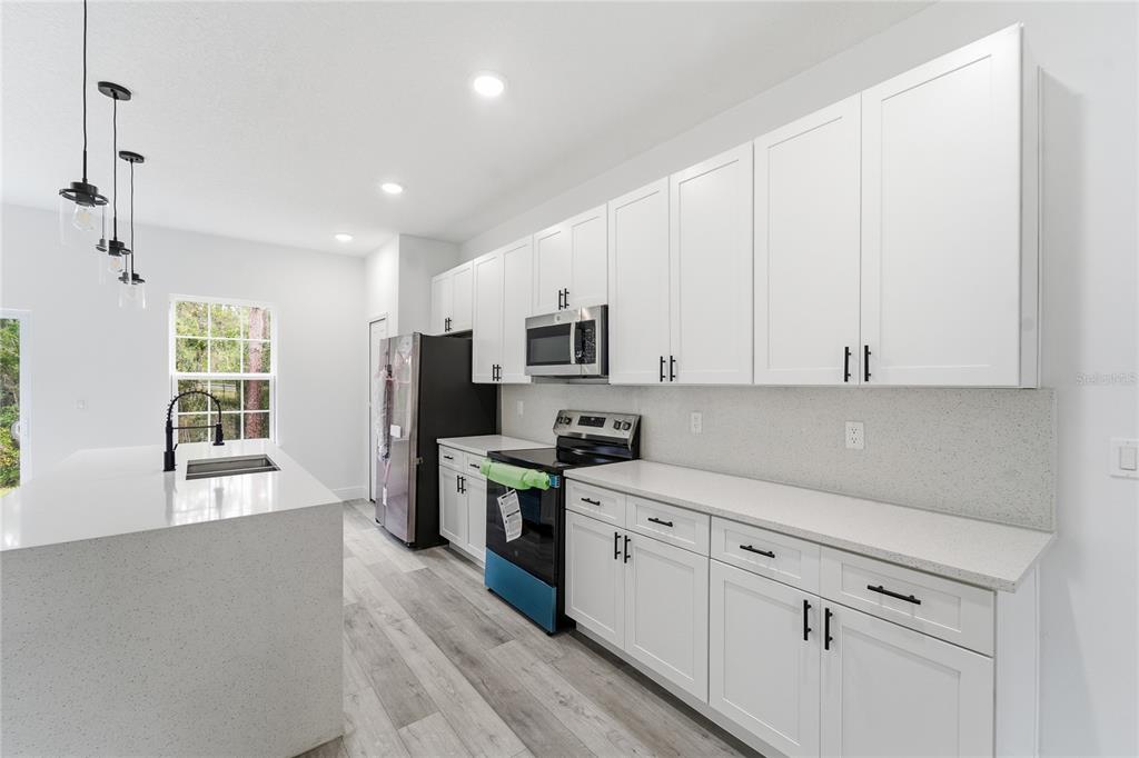 2773 Southwest 147st Street Road Ocala, FL 34473 - Photo 11 of 35 a kitchen with white cabinets and appliances