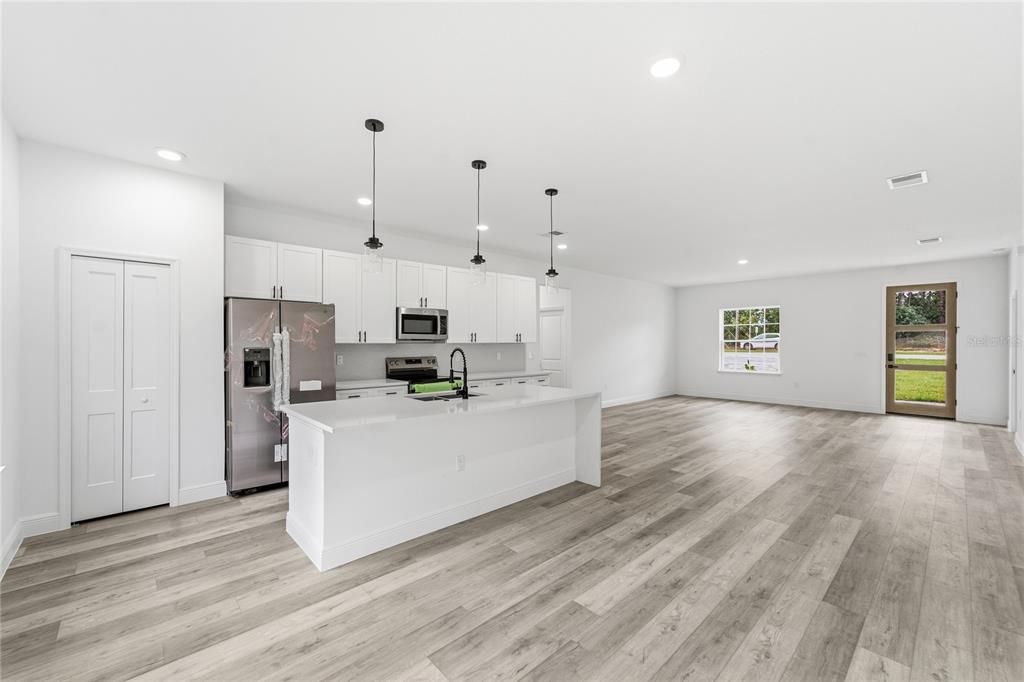 2773 Southwest 147st Street Road Ocala, FL 34473 - Photo 14 of 35 a large kitchen with cabinets wooden floor and stainless steel appliances