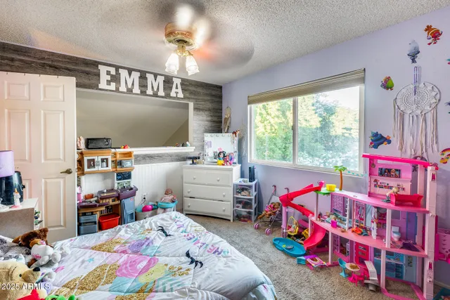 a bedroom with a bed and a flat tv screen on dresser