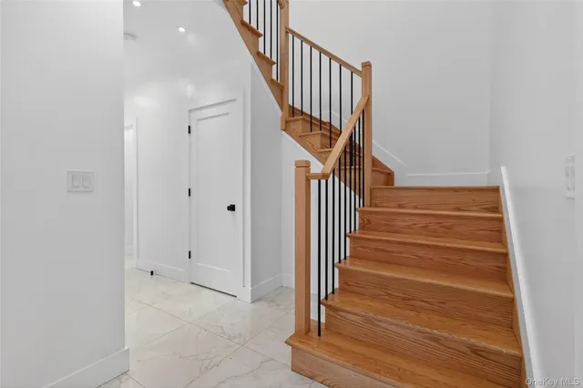 a view of a hallway with wooden floor and staircase