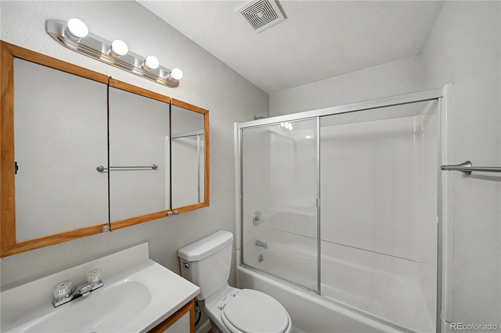 741 Emporia Street, Unit 741 Aurora, CO 80010 - Photo 7 of 11 a bathroom with a shower sink vanity mirror and toilet