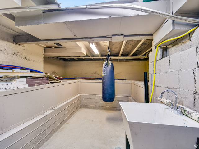 74 South 300 East Springville, UT 84663 - Photo 28 of 48 Lower level utility area featuring a concrete floor, exposed ceiling joists, fluorescent lighting, and a utility sink with a chrome faucet