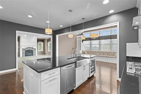 a kitchen with stainless steel appliances granite countertop a sink and a refrigerator