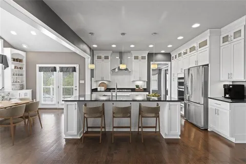 a kitchen with stainless steel appliances granite countertop a refrigerator and a stove top oven