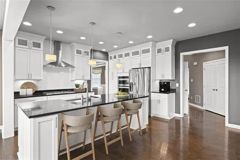 a kitchen with stainless steel appliances granite countertop a stove a sink and a refrigerator