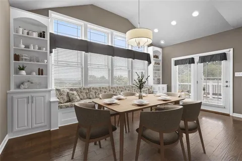 a dining room with wooden floor a chandelier a wooden table and chairs