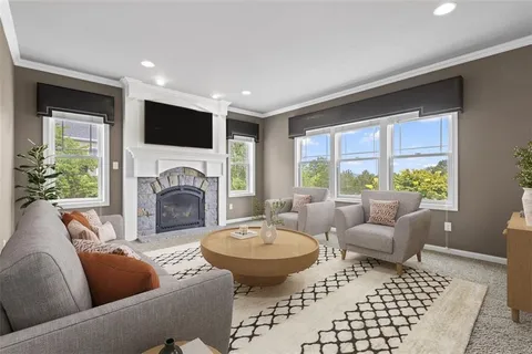 a living room with furniture a large window and a fireplace