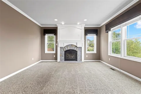 a view of empty room with a fireplace and windows