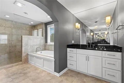 a spacious bathroom with a double vanity sink mirror and bathtub