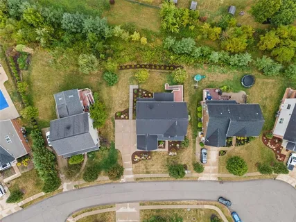 an aerial view of a house with a garden and trees