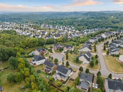 an aerial view of residential houses with outdoor space and trees