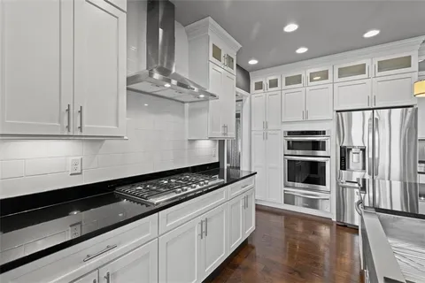 a kitchen with stainless steel appliances a refrigerator and a stove top oven