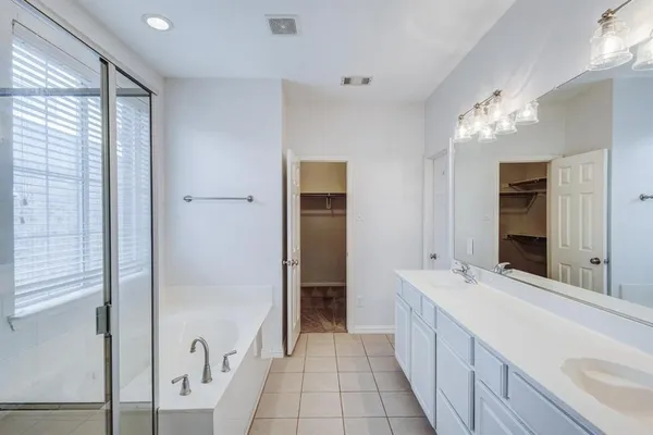 a spacious bathroom with a double vanity sink and a mirror