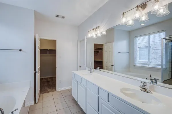 a spacious bathroom with a double vanity sink a mirror and a shower