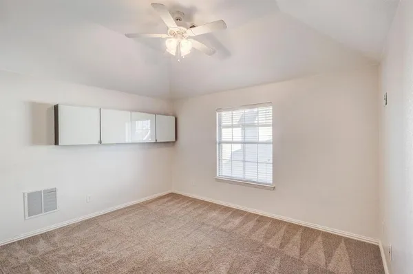 an empty room with windows and fan