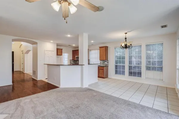 a view of kitchen with granite countertop cabinets and refrigerator