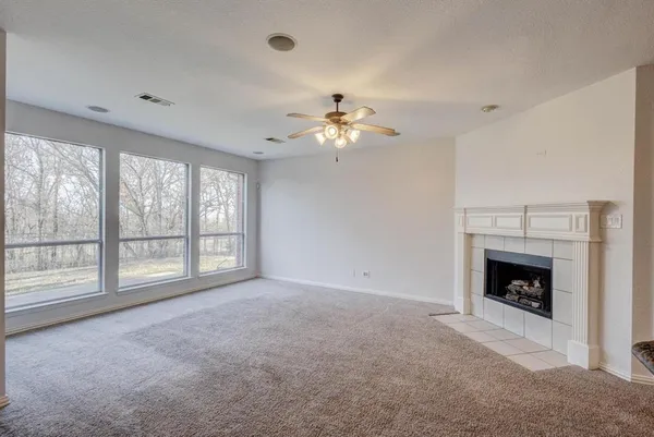 a view of an empty room with a fireplace and a window