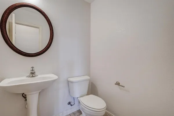 a bathroom with a sink a toilet and a mirror