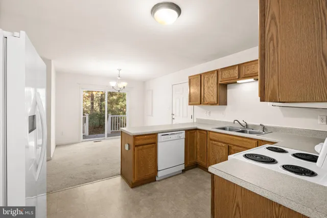 a kitchen with granite countertop a sink stove and refrigerator