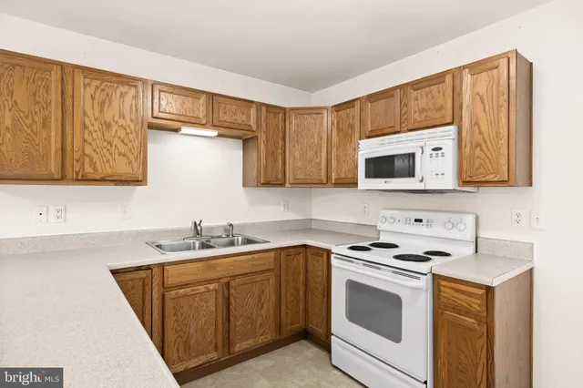 a kitchen with stainless steel appliances granite countertop a sink stove and microwave