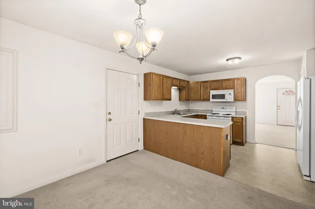 a large kitchen with stainless steel appliances granite countertop a stove a sink dishwasher and a refrigerator with wooden floor