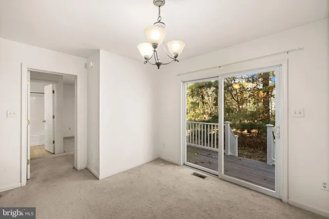 a view of a room with a large window and chandelier