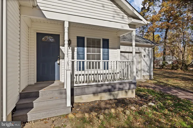 a view of a house with a small yard and wooden floor and fence