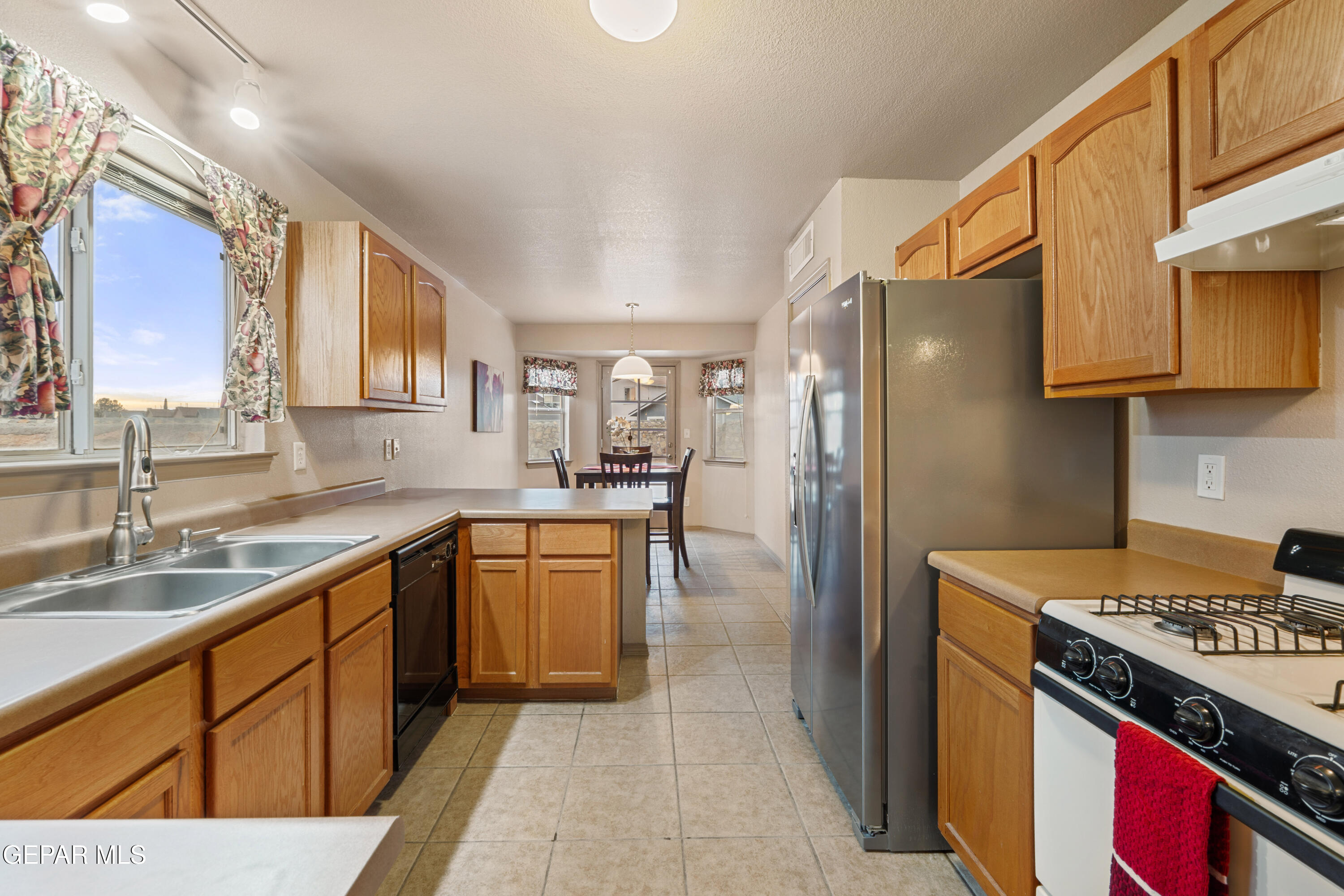 3849 Tierra Roca Place El Paso, TX 79938 - Photo 12 of 44 a kitchen with stainless steel appliances granite countertop a sink stove and refrigerator