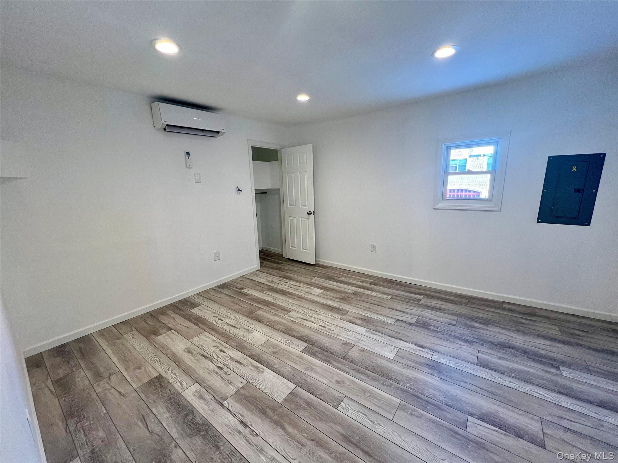 356 Main Street, Unit 1 Farmingdale, NY 11735 - Photo 2 of 4 an empty room with wooden floor and windows
