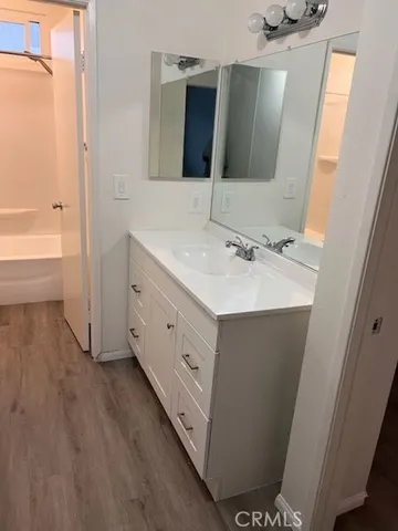 a bathroom with a double vanity sink a mirror and a bathtub