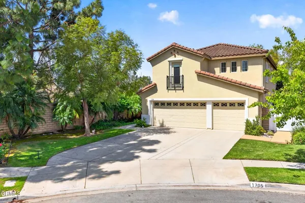 a white house with a tree in front of it