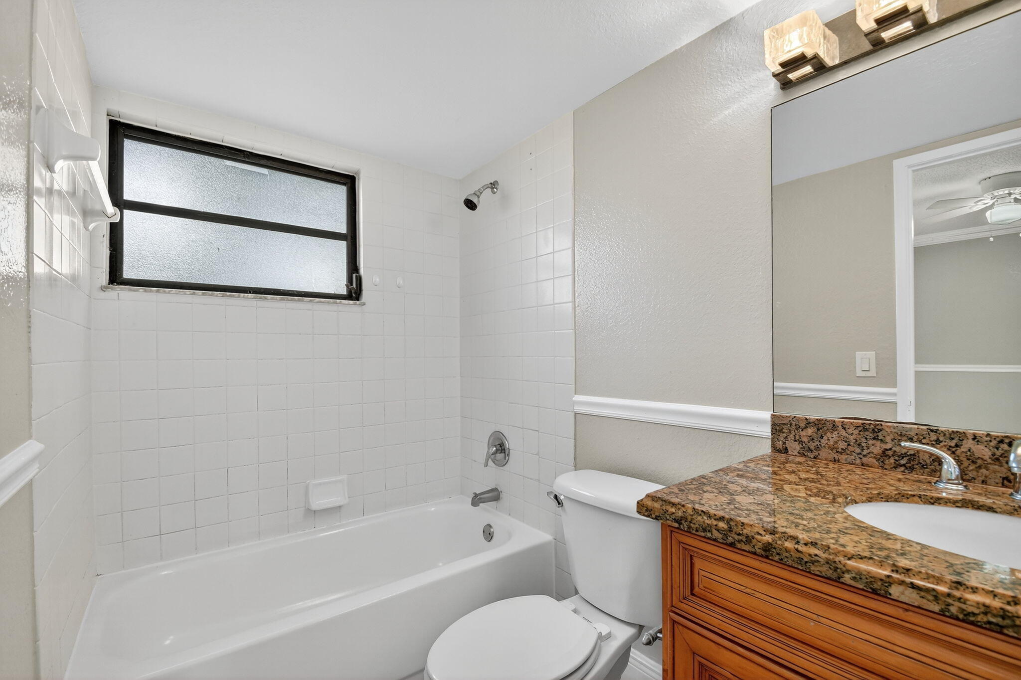 1601 Windorah Way, Unit D West Palm Beach, FL 33411 - Photo 33 of 41 a bathroom with a granite countertop sink toilet and shower