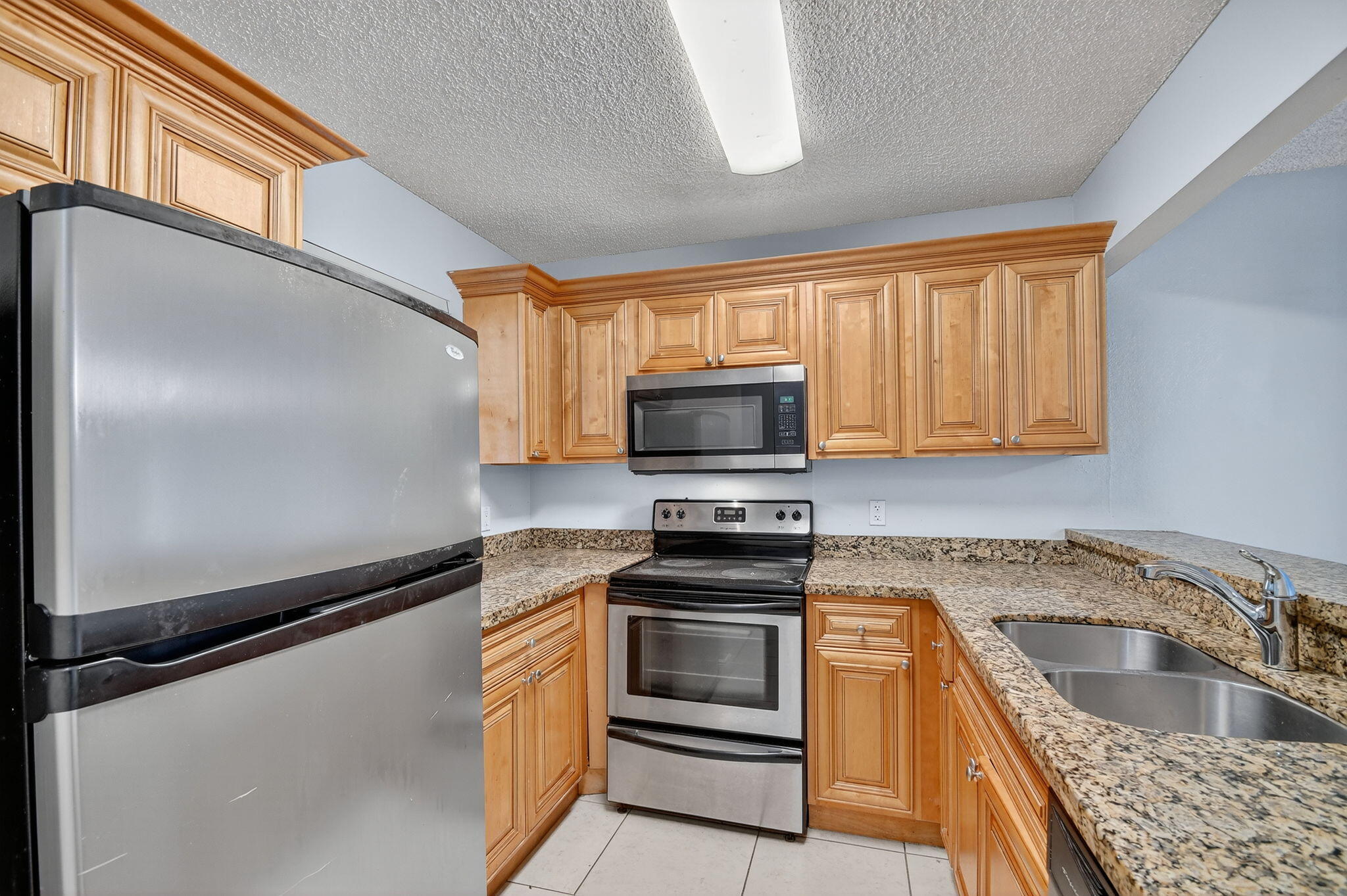 1601 Windorah Way, Unit D West Palm Beach, FL 33411 - Photo 34 of 41 a kitchen with granite countertop a sink stainless steel appliances and cabinets