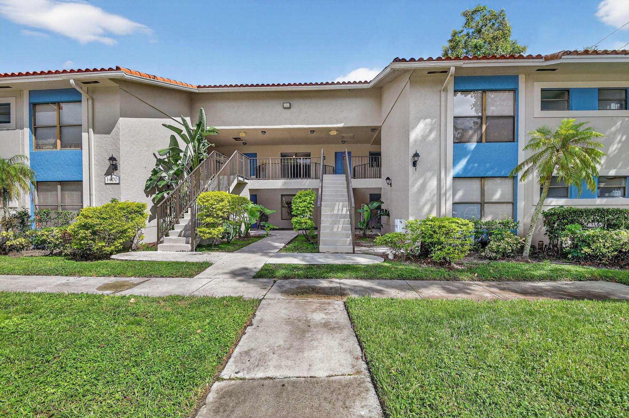 1601 Windorah Way, Unit D West Palm Beach, FL 33411 - Photo 38 of 41 a front view of a house with a yard and potted plants