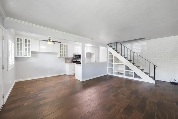 a view of a kitchen with wooden floor and stairs