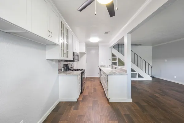 a kitchen with cabinets and wooden floor