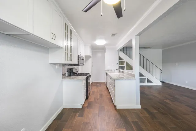 a kitchen with cabinets and wooden floor