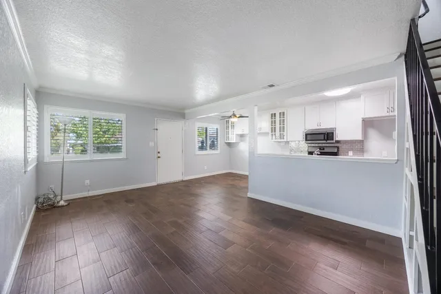 a view of a kitchen with wooden floor and a window
