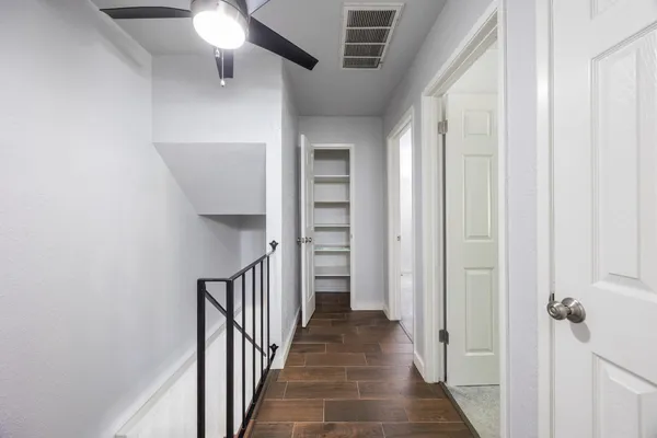 a view of a hallway with wooden floor and staircase
